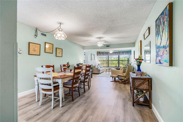 28 Plantation Dr Unit 204, Vero Beach, FL 32966 - dining space featuring a textured ceiling, light wood-type flooring, a ceiling fan, and baseboards