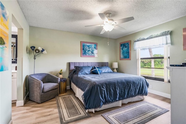 28 Plantation Dr Unit 204, Vero Beach, FL 32966 - bedroom featuring a textured ceiling, light wood finished floors, ceiling fan, and baseboards
