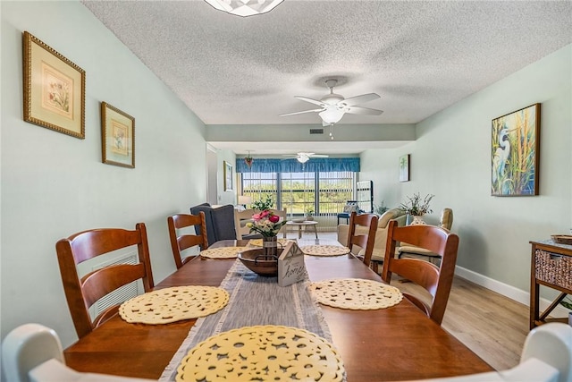 28 Plantation Dr Unit 204, Vero Beach, FL 32966 - dining area with wood finished floors, a ceiling fan, a textured ceiling, and baseboards