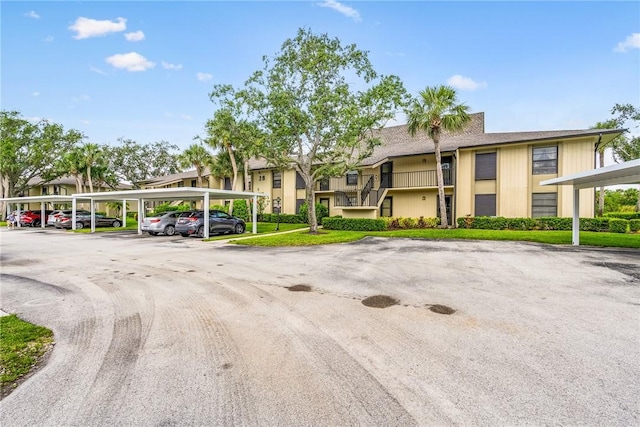 28 Plantation Dr Unit 204, Vero Beach, FL 32966 - view of building exterior with covered and uncovered parking and a residential view