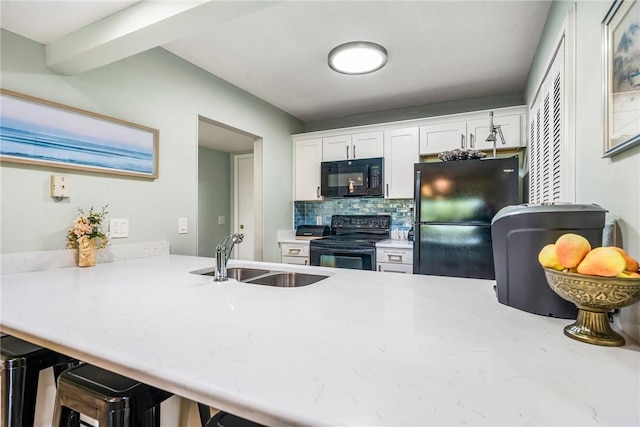 28 Plantation Dr Unit 204, Vero Beach, FL 32966 - kitchen featuring black appliances, a sink, white cabinets, and light countertops