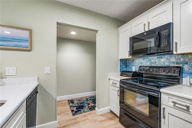 28 Plantation Dr Unit 204, Vero Beach, FL 32966 - kitchen featuring black appliances, light wood finished floors, tasteful backsplash, light countertops, and white cabinetry