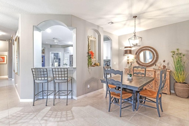 dining room featuring light tile patterned floors and a textured ceiling