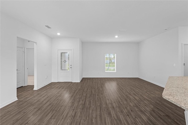 8715 98th Ct, Vero Beach, FL 32967 - unfurnished living room featuring dark wood-style floors, recessed lighting, and baseboards