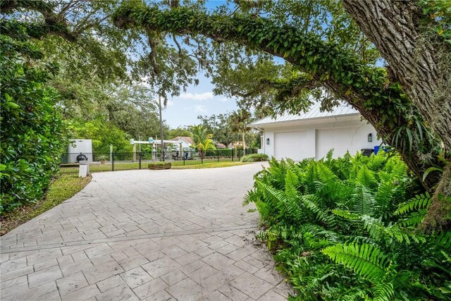 1411 E Camino Del Rio, Vero Beach, FL 32963 - view of community with fence, a garage, and decorative driveway