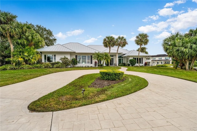 1411 E Camino Del Rio, Vero Beach, FL 32963 - ranch-style house featuring a front yard, metal roof, and curved driveway