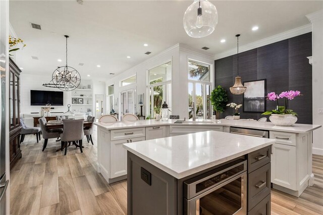 1411 E Camino Del Rio, Vero Beach, FL 32963 - kitchen featuring a peninsula, visible vents, open floor plan, a center island, and built in microwave