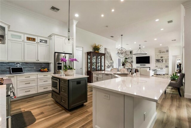 1411 E Camino Del Rio, Vero Beach, FL 32963 - kitchen with ornamental molding, a spacious island, visible vents, and a sink
