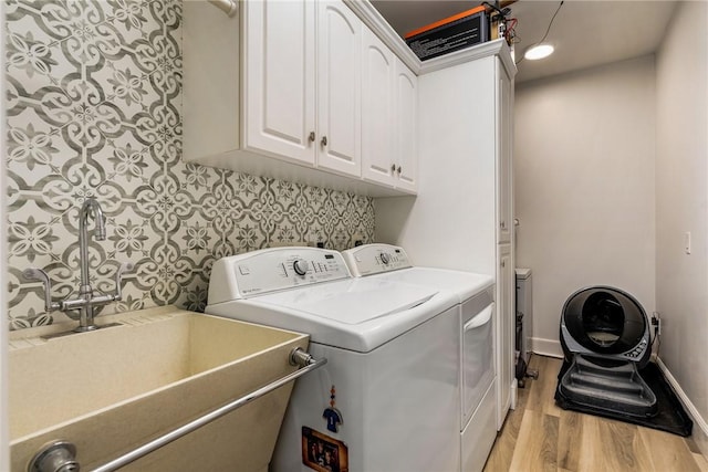 1411 E Camino Del Rio, Vero Beach, FL 32963 - washroom featuring washing machine and dryer, baseboards, a sink, light wood-type flooring, and cabinet space