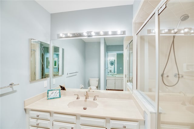 bathroom featuring vanity, toilet, and a shower with shower door