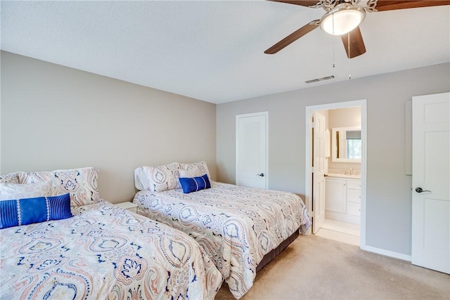 107 W Park Shores Cir Unit 28W, Vero Beach, FL 32963 - bedroom with light carpet, connected bathroom, and ceiling fan