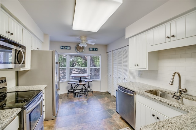 kitchen featuring white cabinetry, sink, ceiling fan, tasteful backsplash, and appliances with stainless steel finishes