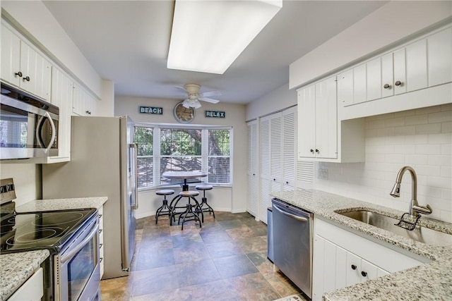 107 W Park Shores Cir Unit 28W, Vero Beach, FL 32963 - kitchen with appliances with stainless steel finishes, ceiling fan, decorative backsplash, and white cabinetry