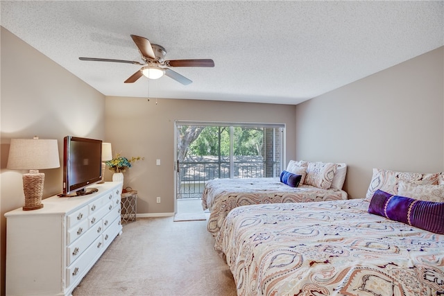 carpeted bedroom featuring access to outside, ceiling fan, and a textured ceiling