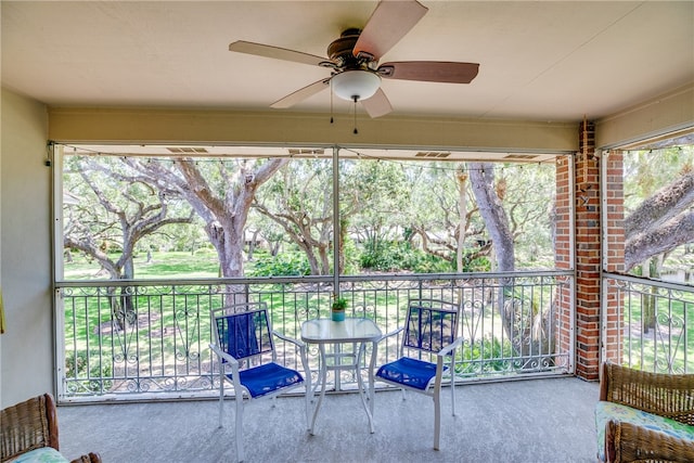 unfurnished sunroom featuring ceiling fan