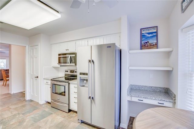 107 W Park Shores Cir Unit 28W, Vero Beach, FL 32963 - kitchen with appliances with stainless steel finishes, white cabinetry, a ceiling fan, open shelves, and light stone counters