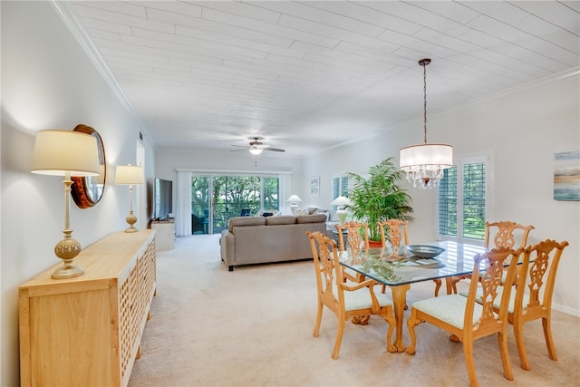 carpeted dining space featuring ceiling fan with notable chandelier and ornamental molding