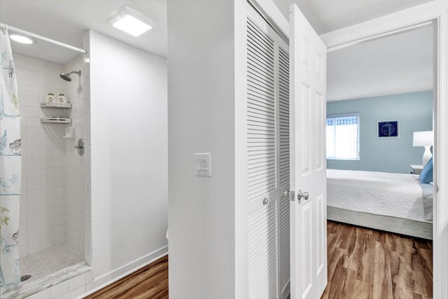 bathroom with walk in shower and hardwood / wood-style floors