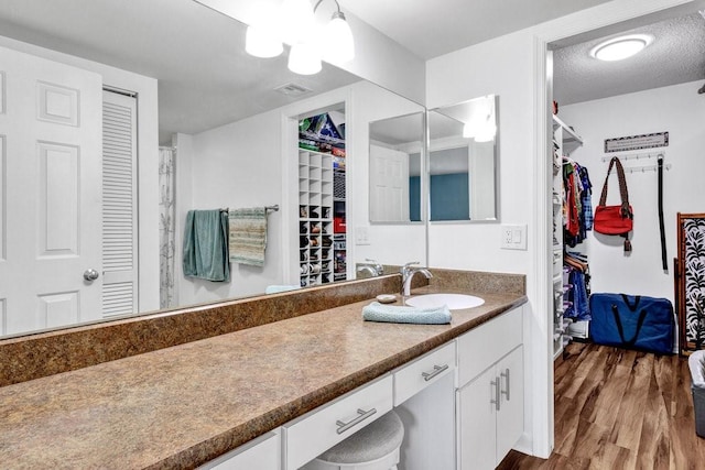 bathroom with vanity, hardwood / wood-style flooring, and a textured ceiling