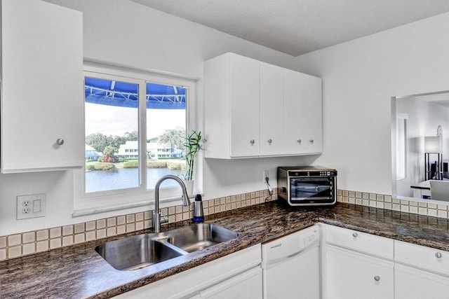 kitchen with white cabinetry, sink, dishwasher, and a water view