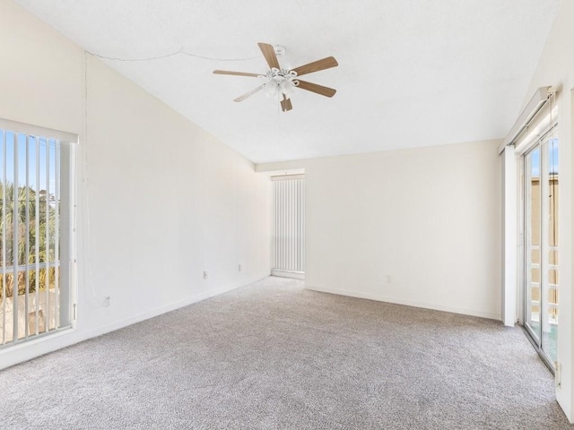 carpeted spare room with ceiling fan, lofted ceiling, and plenty of natural light