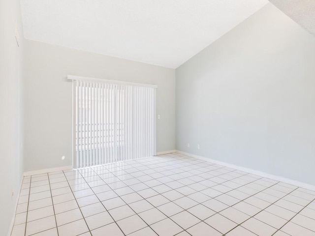 spare room featuring light tile patterned floors and lofted ceiling