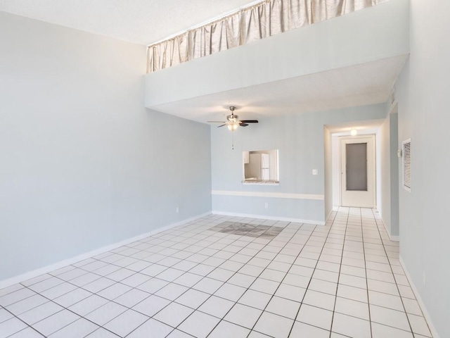 empty room with ceiling fan and light tile patterned floors