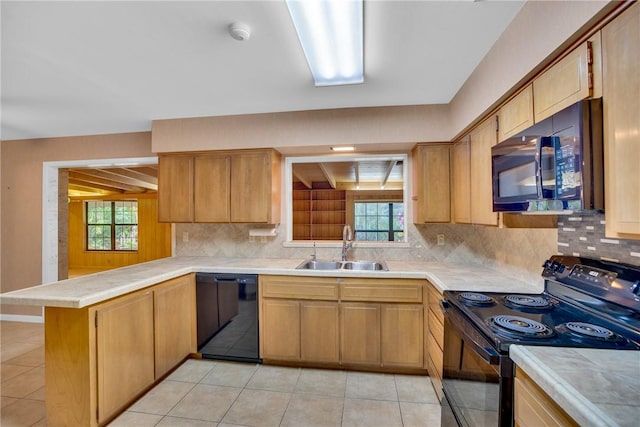 kitchen featuring kitchen peninsula, tasteful backsplash, sink, black appliances, and light tile patterned flooring