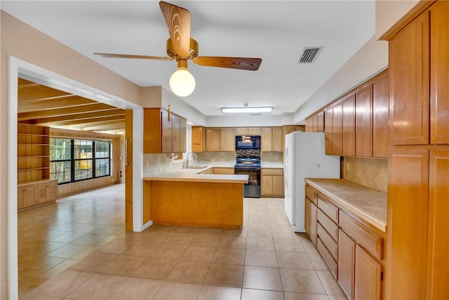 kitchen featuring sink, backsplash, kitchen peninsula, light tile patterned flooring, and black appliances