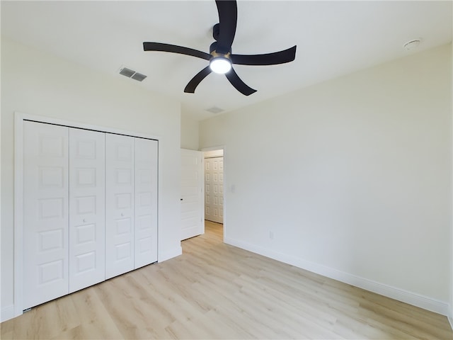 unfurnished bedroom with light wood-type flooring, a closet, and ceiling fan