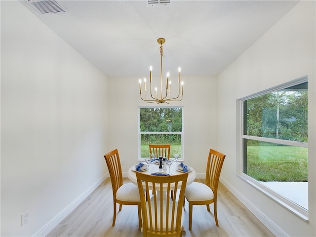 dining space with a chandelier, light hardwood / wood-style flooring, and a healthy amount of sunlight