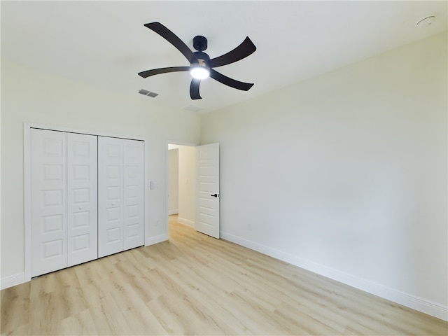 unfurnished bedroom featuring light wood-type flooring, a closet, and ceiling fan