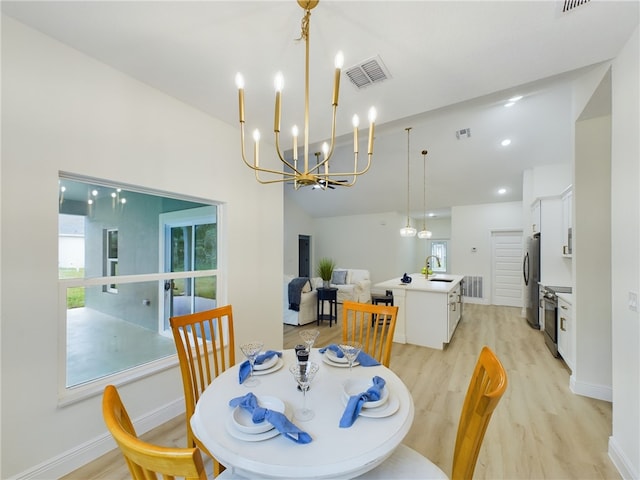 dining room with light hardwood / wood-style flooring, a chandelier, vaulted ceiling, and sink