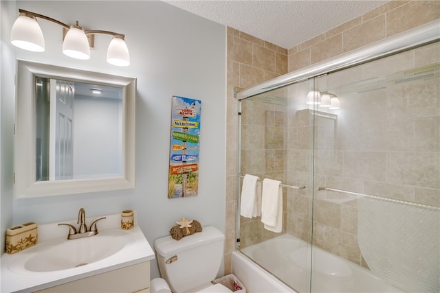 full bathroom with toilet, vanity, bath / shower combo with glass door, and a textured ceiling