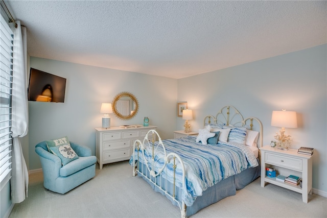 bedroom with a textured ceiling and light carpet