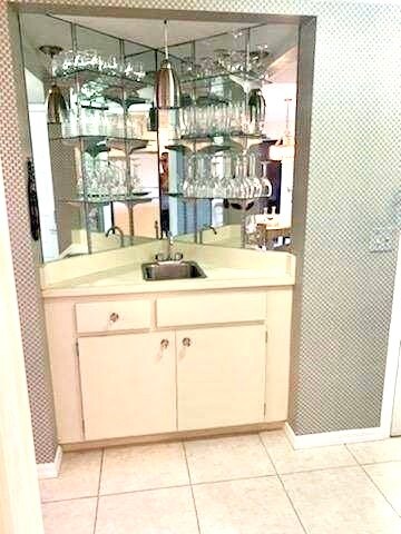 bar with light tile patterned floors and sink