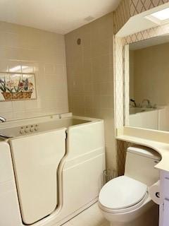 bathroom with tile patterned flooring, vanity, a shower with door, and toilet