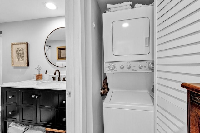 washroom with stacked washer / dryer and sink