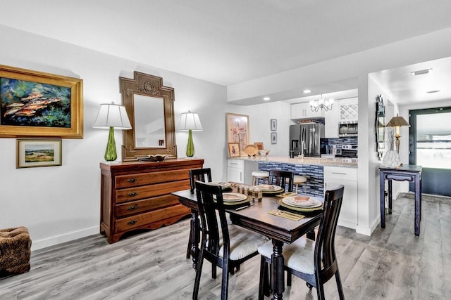 dining space featuring a chandelier and light wood-type flooring