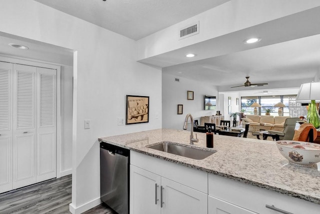 kitchen with dishwasher, sink, white cabinets, and light stone counters