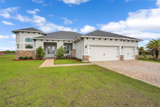 prairie-style house featuring stucco siding, decorative driveway, french doors, a front yard, and a garage