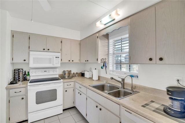 kitchen featuring light tile patterned flooring, white appliances, light countertops, and a sink