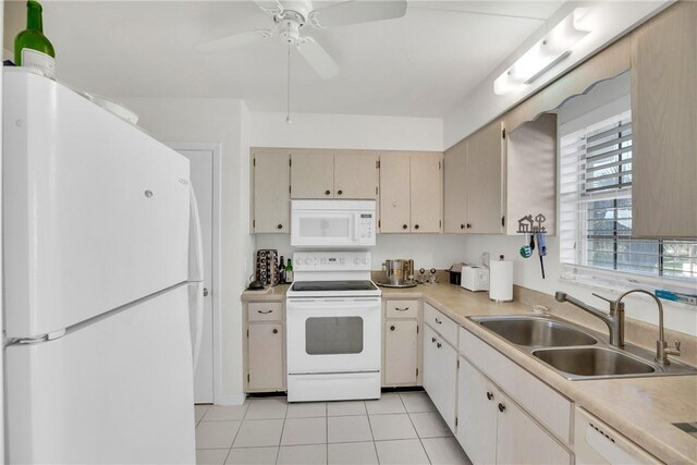 kitchen with a sink, white appliances, light countertops, light tile patterned floors, and ceiling fan