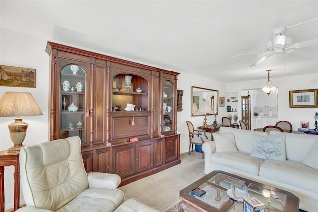 living area with light carpet and ceiling fan