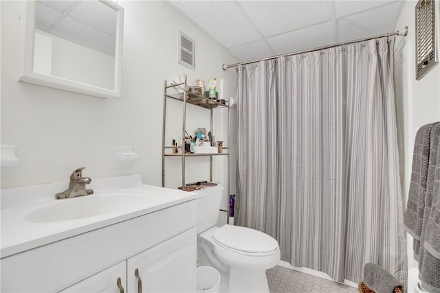 full bathroom with vanity, a shower with curtain, visible vents, a drop ceiling, and toilet