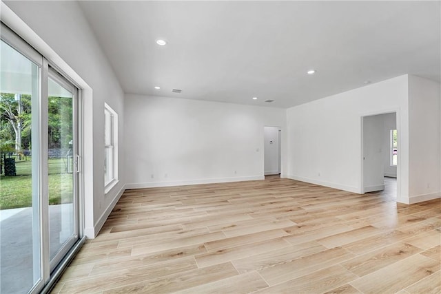 unfurnished room featuring recessed lighting, light wood-type flooring, and a wealth of natural light