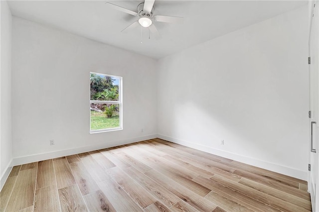 spare room featuring a ceiling fan, light wood-style floors, and baseboards