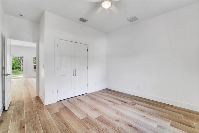 unfurnished bedroom with visible vents, light wood-type flooring, and baseboards