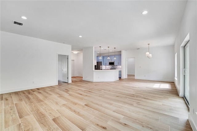 unfurnished living room featuring recessed lighting, visible vents, light wood-style floors, and an inviting chandelier