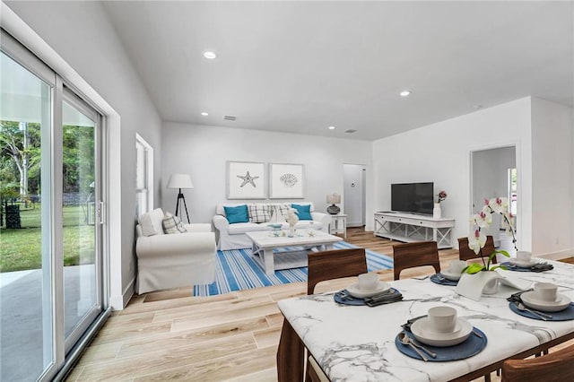 living area with recessed lighting, visible vents, baseboards, and light wood-style flooring